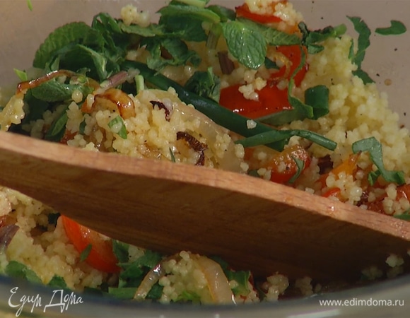 В кускус добавить оставшееся оливковое масло, перемешать вилкой и переложить в глубокую миску, добавить обжаренные овощи, посолить и поперчить, затем всыпать измельченную зелень, влить лимонный сок, все перемешать.