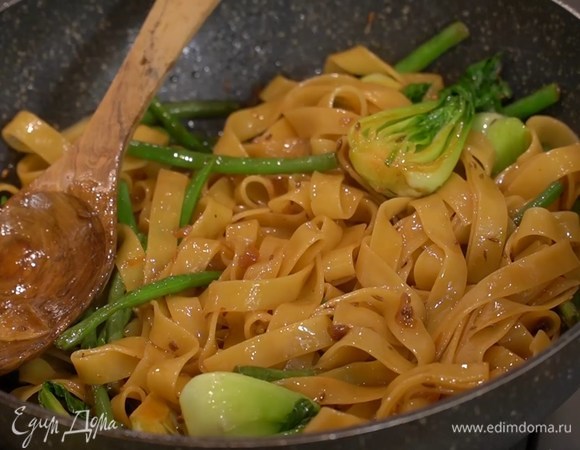 Добавить в сковороду бок-чой, хариссу и перемешать, влить соевый соус, прямо из кастрюли переложить отваренные макароны, еще раз все перемешать и на маленьком огне довести до готовности.