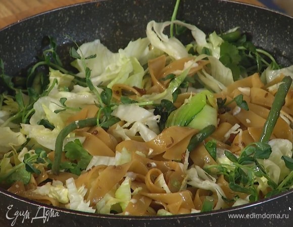 Тофу нарезать небольшими кубиками, выложить к феттучине и перемешать, затем добавить айсберг, ростки гороха и измельченную руками зелень кинзы, снять с огня, перемешать и сразу подавать на стол!