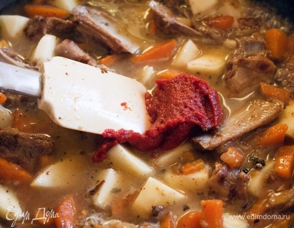 Следом за водой — томатную пасту, перемешиваем и тушим около 30 минут под закрытой крышкой на маленьком огне.