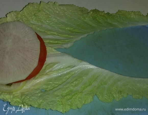 Затем на соленый огурец кладем кружок помидора и сверху еще кружок дайкона.