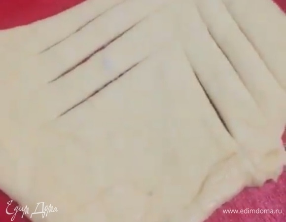 Тесто обмять и разделить на 4 части. Каждую часть раскатать в круг, разрезать пласт теста на 4 сектора-треугольника. На каждом треугольнике сделать 3 надреза с двух сторон.