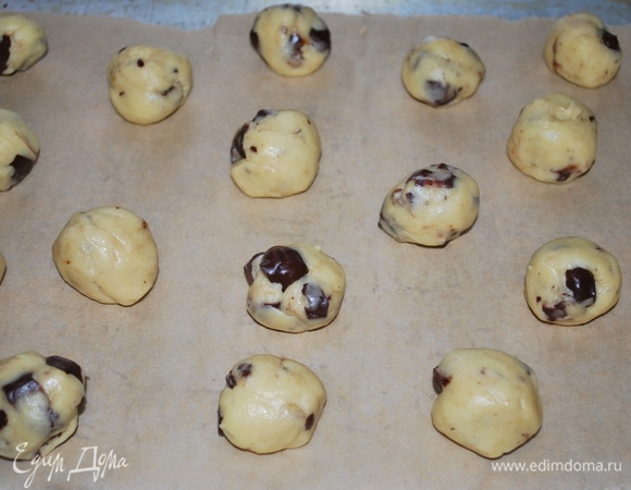 Сформируйте из теста шарики и разложите их на бумагу для выпечки, оставляя между ними место.