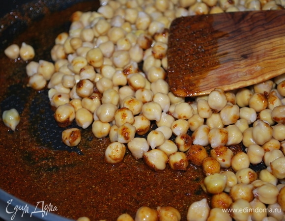 Добавьте нут, перемешайте со специями.