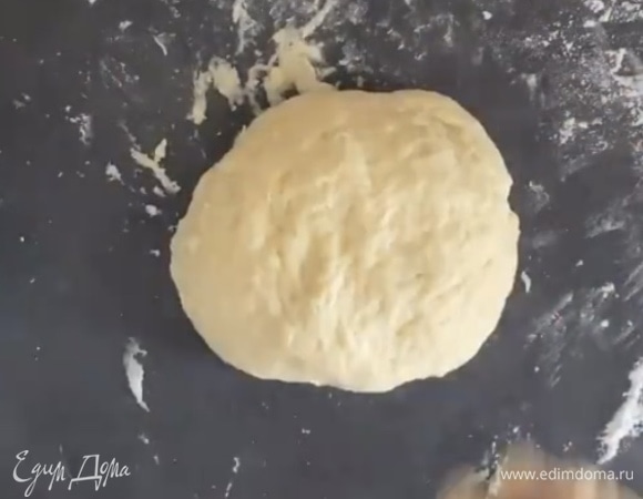 Добавить муку и разрыхлитель и замесить тесто. Если слишком липкое, то добавьте муку. Но оно не должно получиться слишком крутым. Скатать шар и убрать в холодильник, пока делаете начинку.