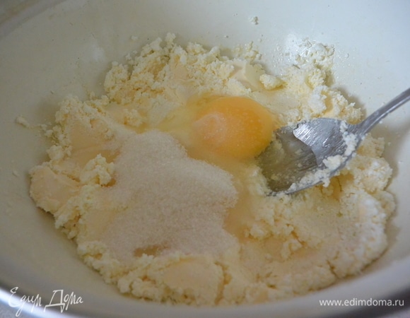 Творог растереть с сахаром, добавить размягченный маргарин, яйца, муку, разрыхлитель и замесить тесто.