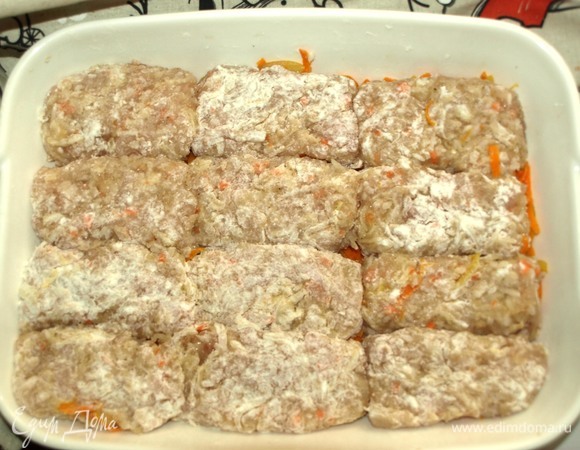 Формируем голубцы. Обваливаем в муке и выкладываем в форму на овощи.