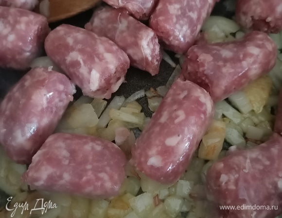 Далее нарезать колбаски небольшими кусочками, добавить к луку и жарить 3–4 минуты.
