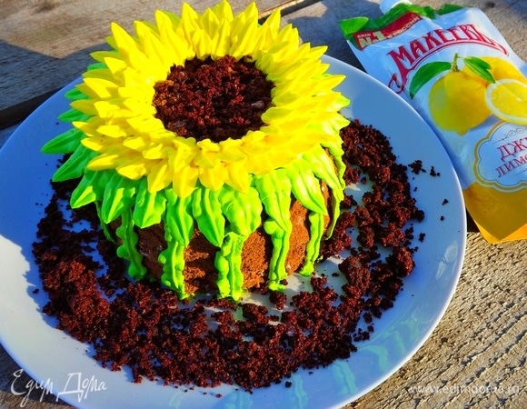 Остальной крем делим на 2 части. В одну часть добавляем зеленый краситель, в другую — желтый. Вымешиваем нужный цвет. Теперь с помощью кондитерского мешка и насадки «листик» делаем зеленым кремом стебель и листики на тортике, а желтым такой же насадкой — лепесточки подсолнуха.