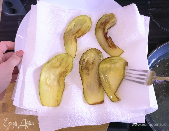 Очистить баклажаны от кожицы, нарезать тонкими пластинками и обжарить на растительном масле (можно также запечь в духовке), затем промокнуть на бумажном полотенце.