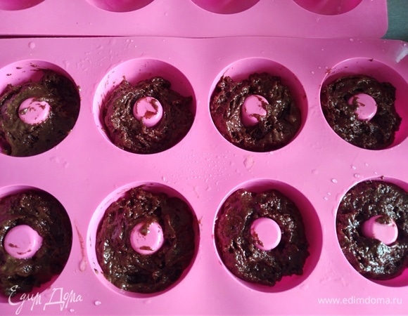 Формочки смазать растительным маслом. Разложить тесто поровну в каждую ячейку, заполняя их на 3/4. Я выкладываю ложкой. Если дома есть кондитерский мешок, то используйте его (им гораздо аккуратнее и удобнее).