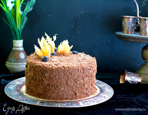 Собрать торт, обернуть ацетатной пленкой и затянуть в кольцо. Поставить груз и убрать на 1 час в холод. Покрыть торт остатками крема, посыпать толченой крошкой и снова убрать на 6–8 часов для пропитки.