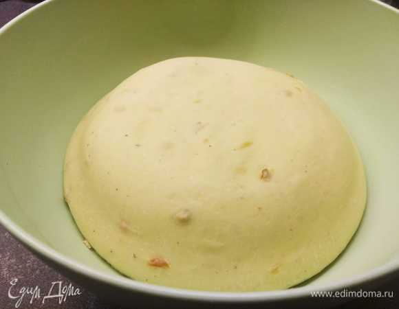 Замесить тесто: соединить муку, дрожжи, молоко, воду, сахар, соль, оливковое масло, сушеный лук, 1 яйцо. Тесто месить не менее 10 минут. Поставить тесто расстаиваться на 1–1,5 часа в теплое место.