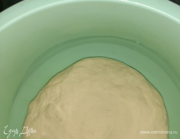 Тесто должно получиться эластичным и не липнуть к рукам. Смазать маслом форму, выложить тесто, накрыть полотенцем и оставить в теплом месте на 1 час.