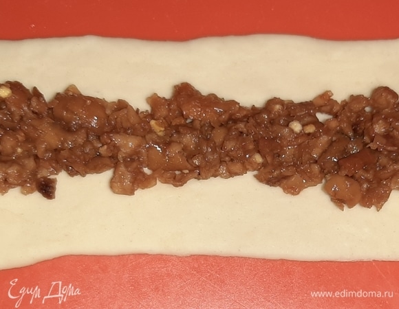 Отщипнуть кусочек теста, раскатать нетонкую полоску длиной 15–20 см. Выложить немного начинки, оставив края полоски без начинки.