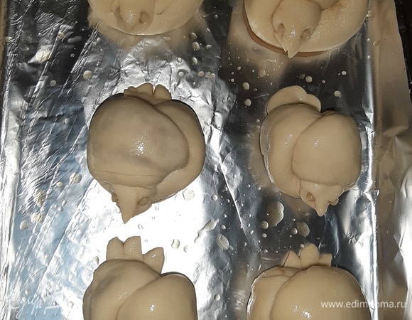 Форму застелить пергаментной бумагой или фольгой, выложить булочки, дать расстояться минут 15. Разогреть духовку до 180°C. Смазать булочки сладким чаем и поставить в духовку на 30 минут.