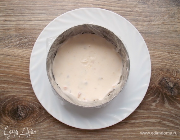 Кухонное кольцо смочите водой и обверните пленкой, поставьте на блюдо. Налейте половину массы в кольцо и поставьте в морозильную камеру на 10–15 минут, чтобы масса застыла.