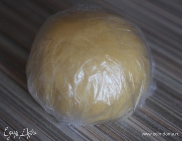 Холодное сливочное масло нарезать кубиками. Добавить сахарную пудру, муку, желток, ванилин и щепотку соли. Все хорошо перемешать. Вымесить гладкое тесто. Оно должно быть мягким и податливым, но не липнуть к рукам. Если тесто рассыпается, можно в него добавить 10 мл (не больше!) холодной воды и снова вымесить. Сформировать шар, завернуть его в пищевую пленку и положить в холодильник на 20 минут. Включить духовку разогреваться до 180°C.