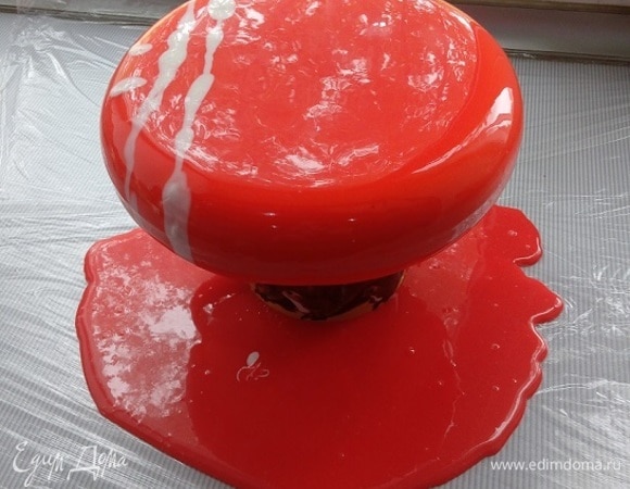 В микроволновке нагреваем глазурь, снимаем пленку и пробиваем еще раз блендером. Измеряем температуру — должна быть 30–35°C. Если образовались пузырьки, нужно процедить через сито. Глазурь готова, и только теперь вынимаем заготовку торта из морозилки, чтобы избежать конденсата. Освобождаем от формы и устанавливаем на стакан (вокруг все затянула пищевой пленкой). Заливаем 1 раз сверху, снимаем излишки глазури шпателем. Переносим на подложку. Ставим в холодильник на 5–10 минут. Вес готового торта — 1060 г.