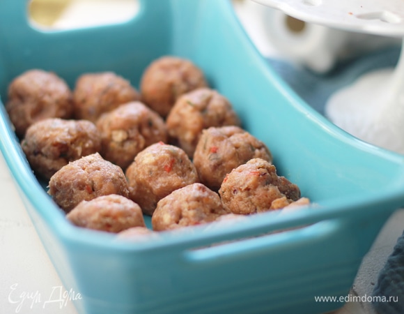 В фарш (у меня из лосося, но непринципиально, можно сделать из филе белой рыбы) прокрутить или очень мелко нарезать небольшую луковицу. Добавить панировочные сухари или хлебные крошки панко (ориентируйтесь по густоте фарша: если фарш жидковат, положите чуть больше сухарей), зелень, соль и белый перец по вкусу. Слепить шарики из рыбной массы (величину выбирайте в зависимости от объемов формы, в которой будете запекать).