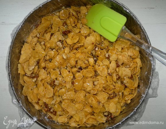 Остудить карамель до теплого состояния, влить в форму с орехами и хлопьями. Массу перемешать, слегка утрамбовать. Поставить в холодильник для охлаждения на 1 час. Можно для более быстрого охлаждения поставить в морозилку на 15–20 минут.