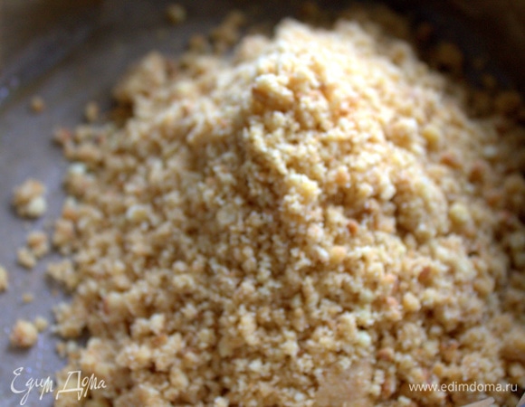 Форму (24 см) застелить пергаментом, смазать и перенести крошку с маслом.