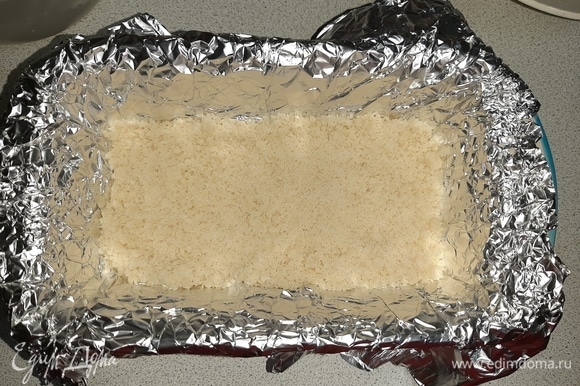 Форму для выпечки застелить фольгой или пергаментом, выложить по поверхности слой крошки.