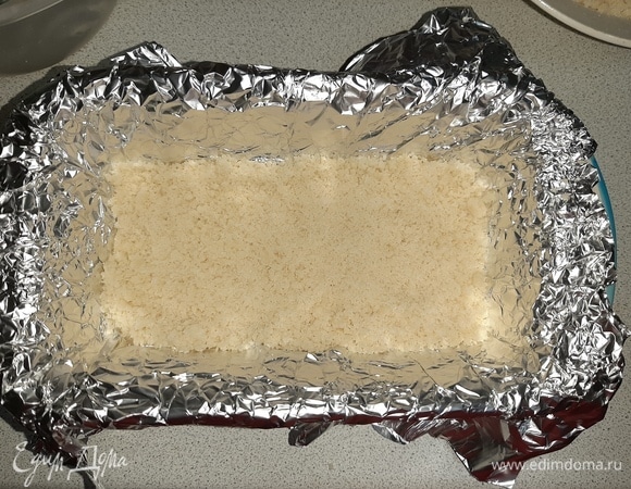 Форму для выпечки застелить фольгой или пергаментом, выложить по поверхности слой крошки.