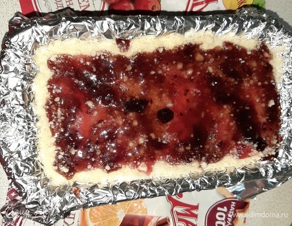 Последним слоем на крошку выложить джем ТМ «МахеевЪ». Разогреть духовку до 180°C, поставить пирог и запекать в течение получаса.