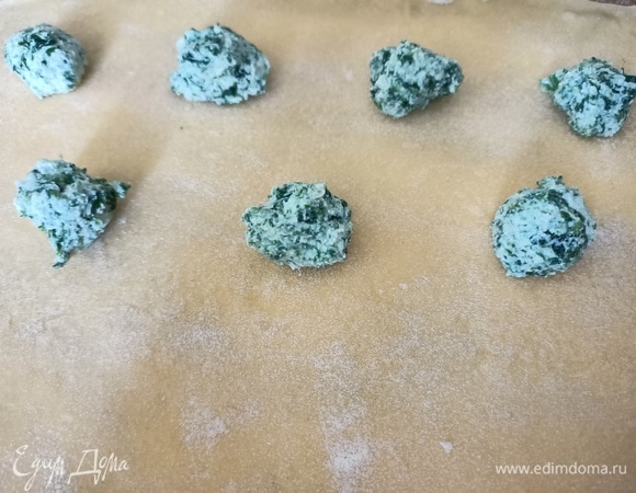 Рабочую поверхность посыпать мукой. Раскатать тонкое тесто. Выложить начинку на расстоянии 3 см друг от друга.