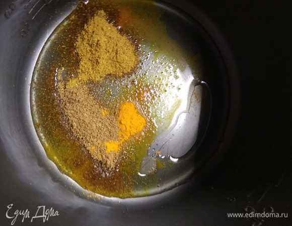 На дно чаши мультиварки налить масло и высыпать куркуму, хмели-сунели, кориандр. Тщательно смешать специи с маслом.
