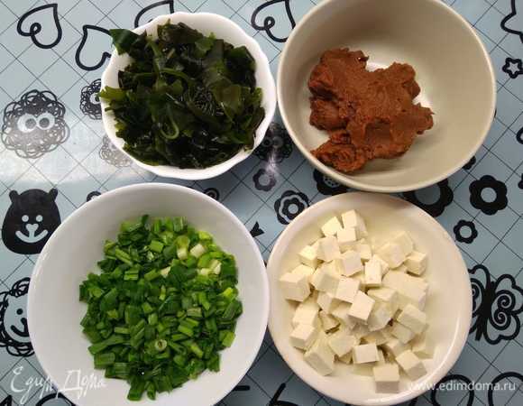 Подготовить ингредиенты: нарезать тофу на квадратики не более 1 см, нашинковать лук, подготовить мисо-пасту. Предварительно необходимо залить холодной водой сухие водоросли вакаме и оставить на 15 минут для набухания.