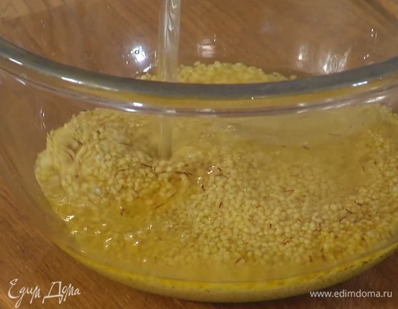 Кускус всыпать в глубокую миску, добавить шафран, влить оставшееся оливковое масло и горячий бульон, накрыть тарелкой или пищевой пленкой и дать настояться.