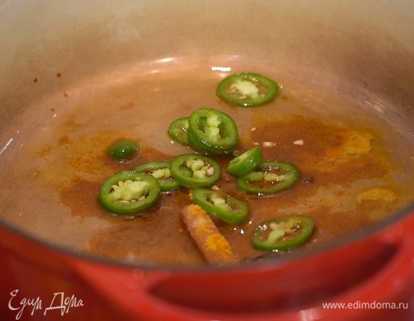 В тяжелой кастрюле с толстым дном разогреть оливковое масло, добавить корицу, бадьян, гвоздику, куркуму, кайенский перец, имбирь, паприку и нарезанный халапеньо.