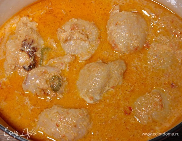 Замаринованные бедрышки переложить в кастрюлю с луком, чесноком и специями, посолить, добавить кокосовую массу, помидоры в собственном соку и кокосовое молоко, накрыть крышкой и готовить 20‒25 минут.