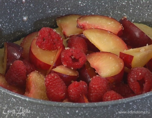 В разъемную форму выложить тесто, разровнять его, сверху разложить сливы с малиной.