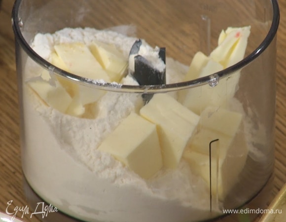 Приготовить присыпку: 100 г предварительно охлажденного сливочного масла нарезать кубиками и выложить в чашу блендера, всыпать 100 г муки и измельчить все в крошку.