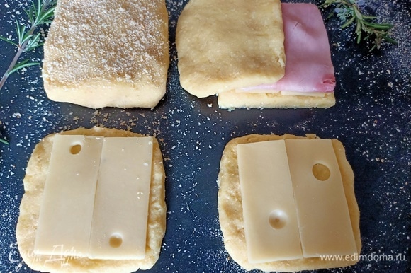 Рабочую поверхность посыпать панировочными сухарями. Картофельное пюре разделить на восемь равных частей. Сформировать тосты. На основу выложить сыр и ветчину.