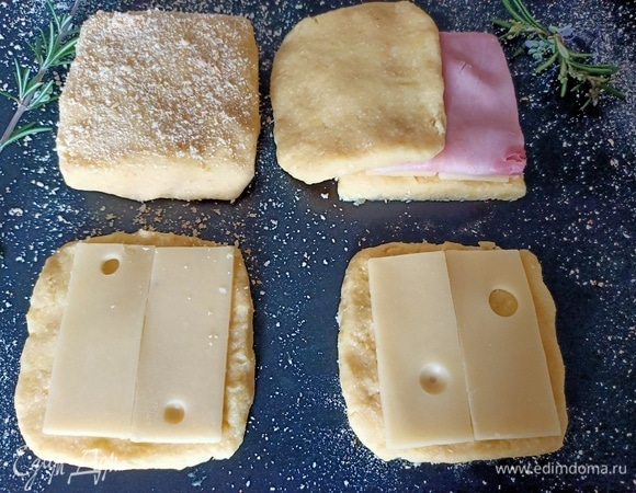 Рабочую поверхность посыпать панировочными сухарями. Картофельное пюре разделить на восемь равных частей. Сформировать тосты. На основу выложить сыр и ветчину.