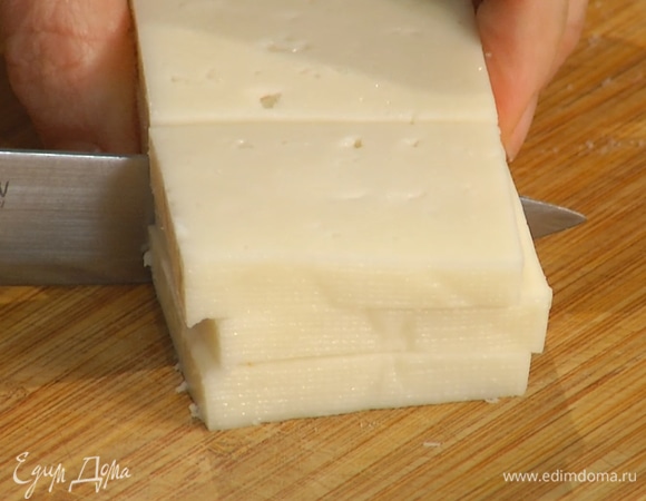 Сыр нарезать крупными ломтиками толщиной 1/2 см, затем разрезать их пополам.