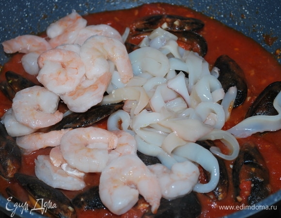 Кальмары нарежьте кольцами, мидии очистите ножом (если необходимо) от посторонних наростов. Мидии добавьте к соусу и закройте крышкой, варите все вместе в течение 5 минут, пока у них не раскроются раковины. Тем временем отварите спагетти в кипящей подсоленной воде до состояния альденте. Пока паста варится, к соусу с мидиями добавьте креветки и кальмары.