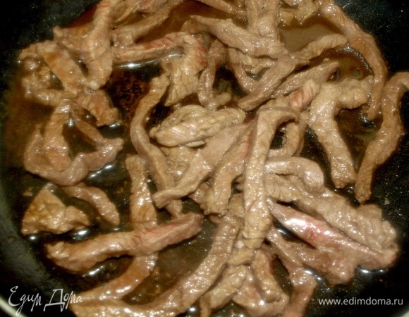 На раскаленную сковороду добавляем 1 ч. л. растительного масла. Обжариваем полоски говядины 1 минуту. Добавляем соевый соус. Обжариваем 1 минуту. Если готовить дольше, говядина не будет сочной.