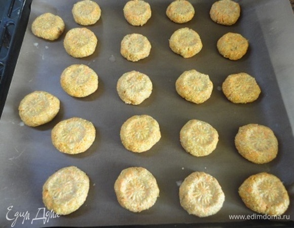 Соединить жидкие и сухие ингредиенты и замесить тесто. Мокрыми руками сформовать шарики (примерно по 3 см в диаметре), выложить их на противень, выстланный бумагой или ковриком, и слегка расплющить.
