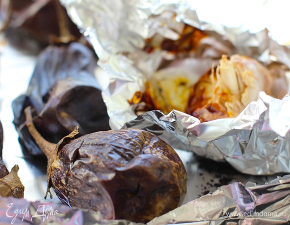 Противень выстелить фольгой. Баклажаны (берите бэби-баклажанчики, мелкие; если крупные, то нужно 2 шт.) вымыть, проколоть вилкой насквозь, выложить на противень. У половины головки чеснока срезать верхушку, выложить на кусочек фольги, капнуть внутрь мед и кунжутное масло, свернуть фунтиком и добавить на противень к баклажанам. Запекать при 200°C до легкого обугливания кожицы или до мягкости.