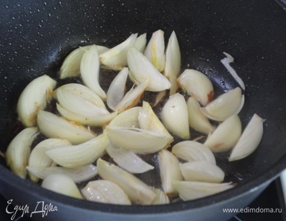 А в этом же жире обжариваем нарезанный дольками лук, пока он не станет золотистым.