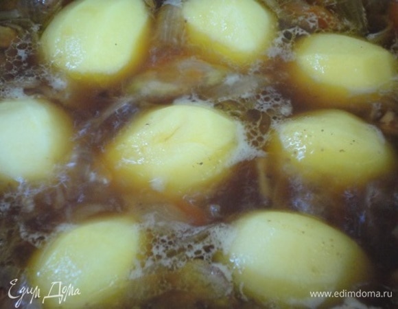 Картофель небольшого размера очистить и целиком выложить поверх мяса. Посолить, прикрыть крышкой и тушить 35–45 минут. Можно готовить до готовности картофеля и подавать. Но блюдо будет интереснее, если готовое жаркое еще поместить в духовку и дать возможность картофелю зарумяниться.