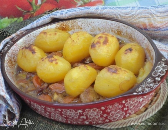 У меня жаровня большая и не подходит для подачи на стол. Поэтому я переложила жаркое в форму для запекания. Сверху выложить картофель и поставить в духовку на 25–30 минут при температуре 200°C.