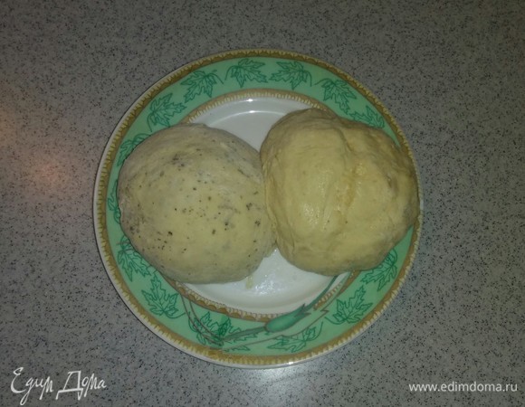 Затем делим полученное тесто на две равные части. После чего в одну часть добавляем сушеный чеснок, а в другую часть добавляем сушеный базилик. Вымешиваем руками тесто. Тесто для лепешек готово. На полчаса отправляем тесто в холодильник.