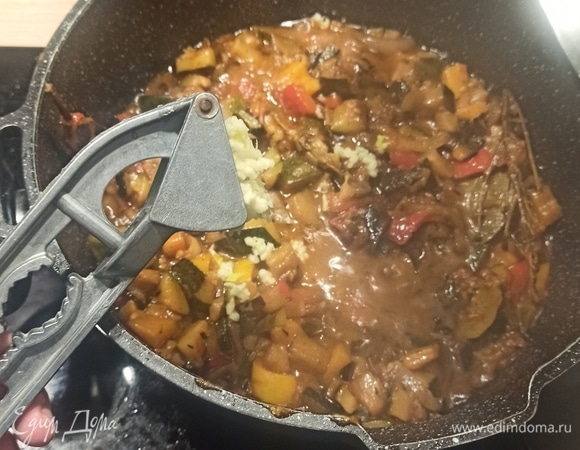 За 10 минут до окончания готовки чеснок выдавить в кастрюлю, помешать и тушить еще 10 минут.