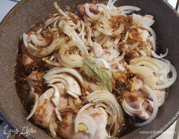 В сковороду выложить обжаренные бедра, сверху выложить лук и залить маринадом. Огонь уменьшить и тушить 20 минут. Через десять минут бедра перевернуть.